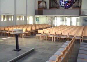 Grosser Kirchenraum mit Holzstuehlen
