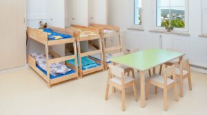 Holzkinderbetten und Kindertisch mit Stuehlen