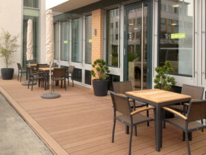 Holzterrasse mit Tischen und Stühlen